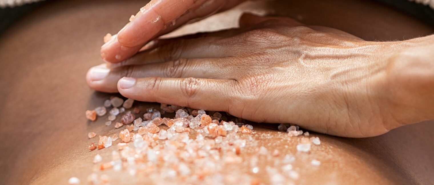 Hände eines Masseurs bei einer ayurvedischen Salz-Massage