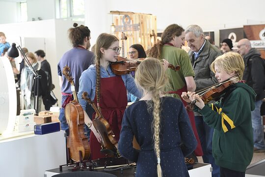 Kinder am Stand eines Geigenbauers