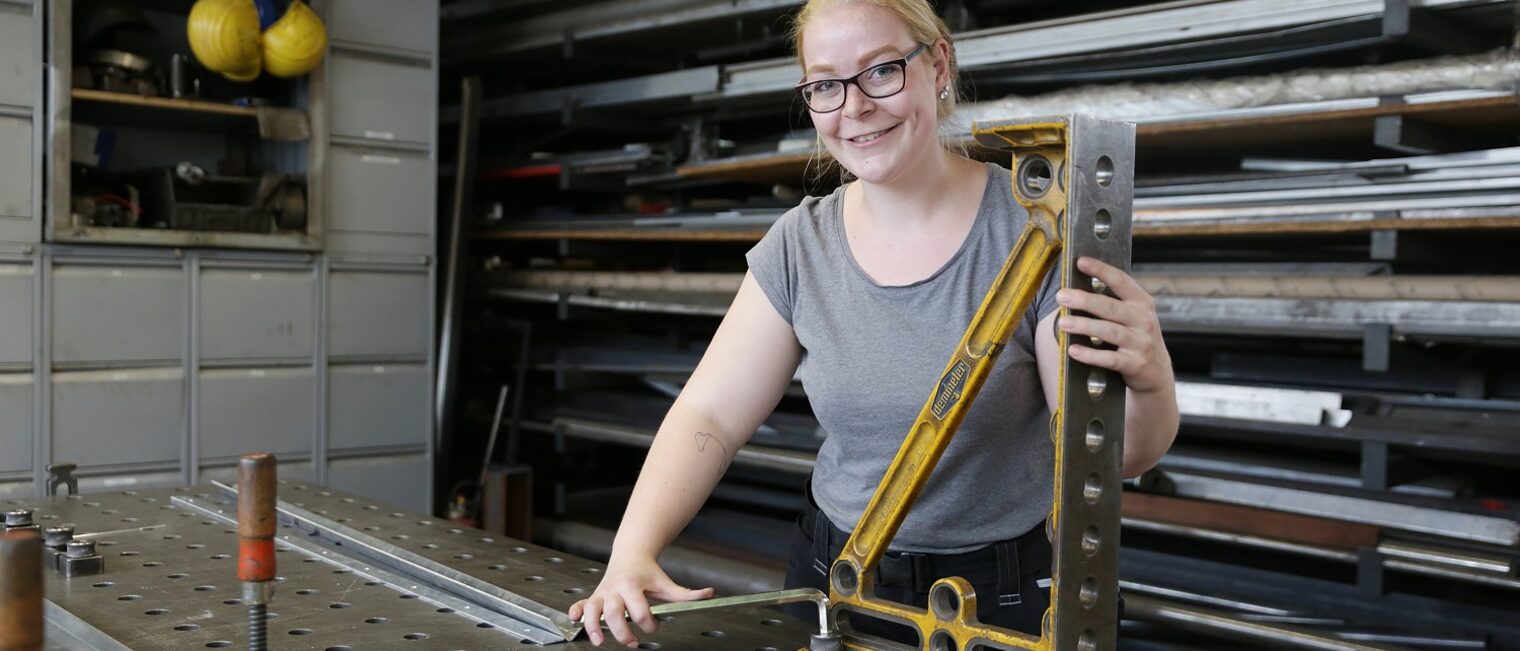 Paula Düllmann steht am Werktisch in der Metallbauwerkstatt ihres Vaters in Krefeld