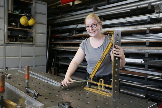 Paula Düllmann steht am Werktisch in der Metallbauwerkstatt ihres Vaters in Krefeld